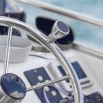 Round,Metal,Steering,Wheel,Of,A,Small,Electric,Rental,Boat.