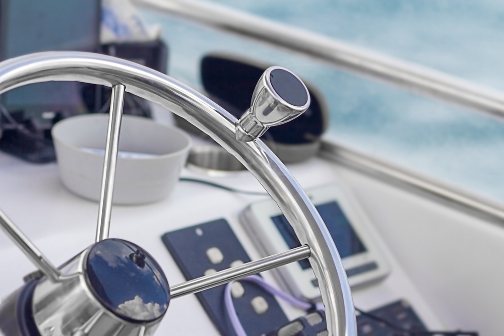 Round,Metal,Steering,Wheel,Of,A,Small,Electric,Rental,Boat.