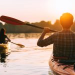 Meeting,Sunset,On,Kayaks.,Rear,View,Of,Beautiful,Young,Couple