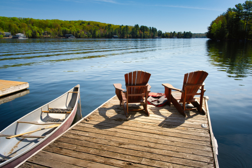 Two,Adirondack,Chairs,On,A,Wooden,Dock,Facing,The,Blue